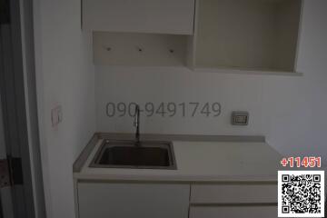 Compact white kitchen interior with built-in sink and cabinets