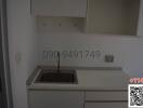 Compact white kitchen interior with built-in sink and cabinets