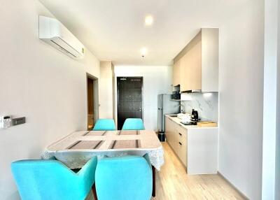 Modern kitchen with dining area featuring turquoise chairs and wooden table