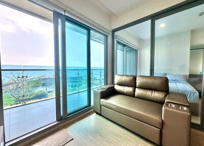 Ocean view modern living room with large windows and comfortable seating