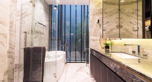 Elegant modern bathroom with marble walls and dark wood accents