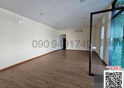 Spacious empty living room with hardwood flooring and large windows