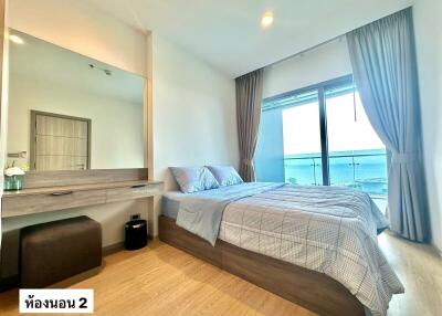 Spacious bedroom with ocean view, modern furniture, and large window