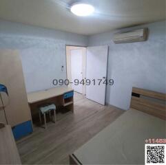 Spacious bedroom with wooden flooring, air conditioning, and built-in storage