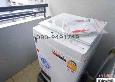 Washing machine on apartment balcony with urban view