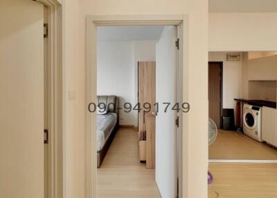 View of a modern apartment hallway leading to bedroom and kitchen