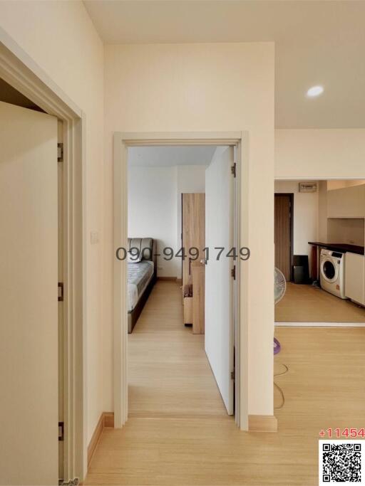 View of a modern apartment hallway leading to bedroom and kitchen