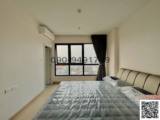 Spacious bedroom with large windows and city view