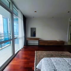 Spacious bedroom with large windows and city view