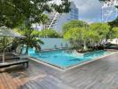 Elegant outdoor swimming pool with lounge chairs and lush greenery