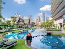 Luxurious outdoor pool area with city skyline view, lounge chairs, and traditional pavilion