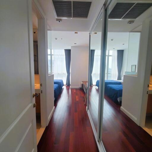 Spacious bedroom interior with mirror wardrobe doors and hardwood flooring