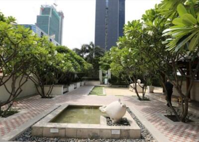 Tranquil garden courtyard in an urban environment with lush greenery and water features