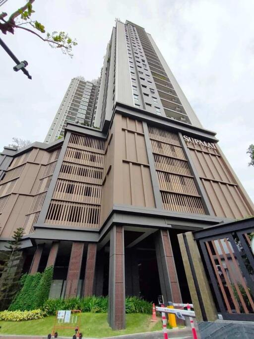 Exterior view of a modern high-rise residential tower with distinctive architectural design