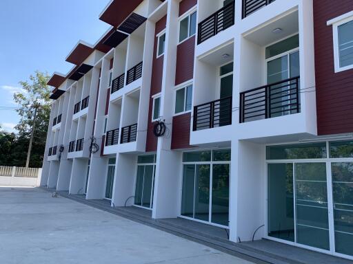 Modern apartment building with large glass windows and red and white exterior