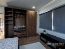 Modern bedroom with built-in wooden wardrobe and large bed