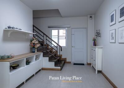 Spacious and elegant entryway with staircase and modern decor