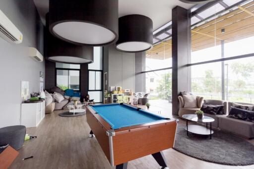 Spacious modern living room with pool table and high ceilings