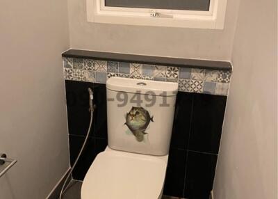 Compact bathroom with decorated tiles and modern toilet