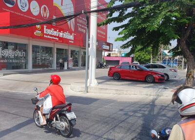 Street view of commercial property with visible storefronts and traffic