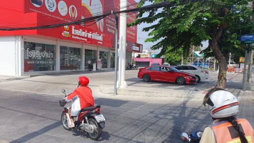 Street view of commercial property with visible storefronts and traffic