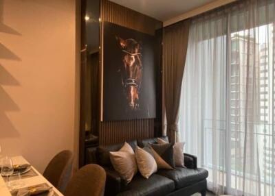 Modern living room with a large horse artwork, black leather sofa, and sheer curtains