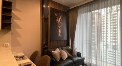 Modern living room with a large horse artwork, black leather sofa, and sheer curtains