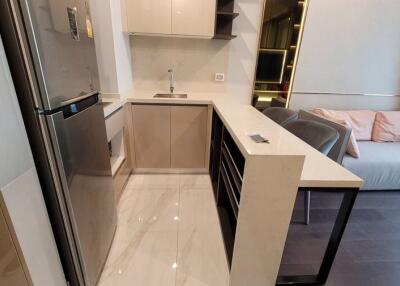 Modern kitchen with integrated living area featuring sleek design and neutral tones