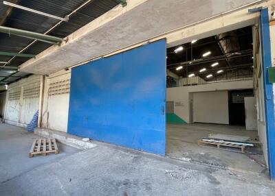 Spacious industrial building interior with large blue sliding door