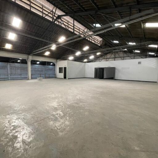 Spacious industrial warehouse interior with high ceiling and multiple lighting fixtures