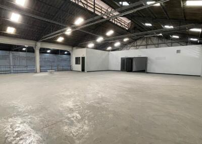 Spacious industrial warehouse interior with high ceiling and multiple lighting fixtures