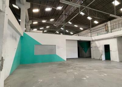 Spacious industrial warehouse with high ceiling and turquoise accent wall