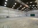 Spacious industrial warehouse interior with high ceiling and lighting
