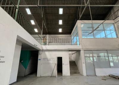 Spacious industrial warehouse interior with high ceiling and natural lighting