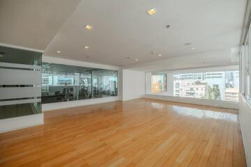 Spacious living room with hardwood flooring and city view