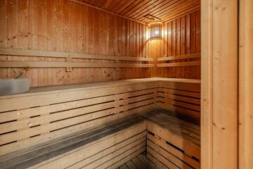 Interior of a wooden sauna room with built-in bench seating and soft lighting