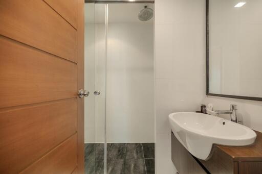 Modern bathroom with glass shower and wooden door