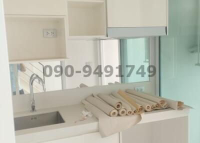 Compact modern kitchen with white cabinetry and stainless steel sink