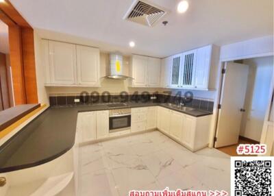 Spacious modern kitchen with white cabinetry and marble flooring