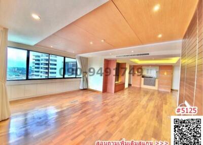 Spacious and well-lit living room with hardwood floors and panoramic city views