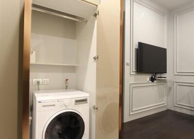 Compact laundry room with built-in appliances and adjacent dining area