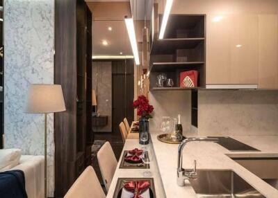 Modern kitchen with dining area featuring marble countertops and elegant lighting