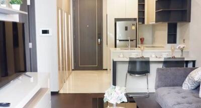 Modern kitchen with integrated living room area, featuring stylish decor and appliances