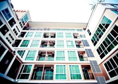 Modern multi-story residential building with prominent windows and balconies