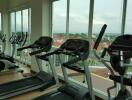 High-rise apartment building gym with treadmills overlooking the city