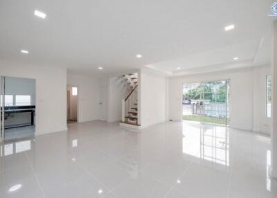 Spacious and bright living area with staircase and glossy floor