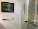 Modern bathroom with glass shower and framed artwork