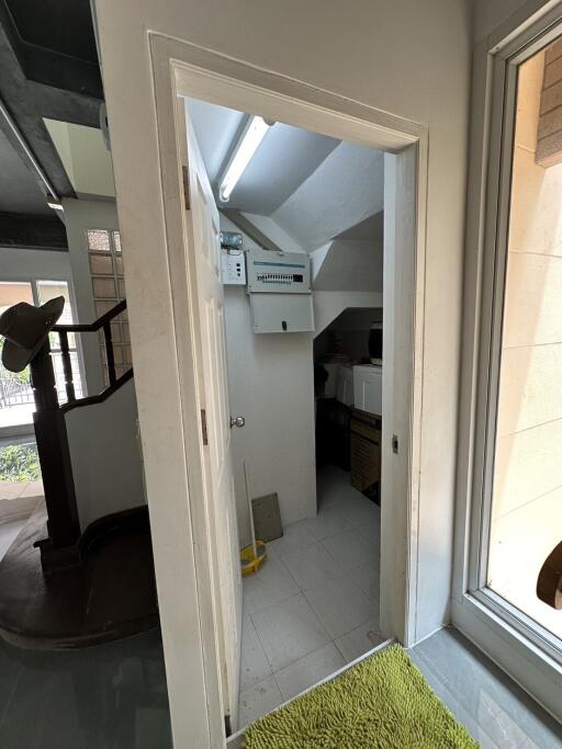 Interior view of a small utility room with sloped ceiling and natural light