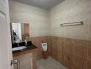 Modern tiled bathroom with urinal and sink