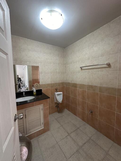 Modern tiled bathroom with urinal and sink